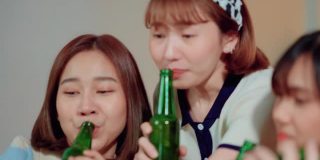一名年轻的亚洲女子在私人聚会上喝酒和吃零食时拍了一张自拍照。