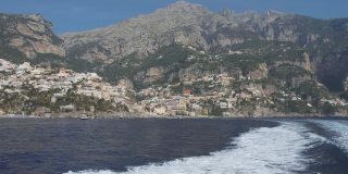 摩托艇漂浮在海岸山的岩石斜坡上离开城市。意大利波西塔诺