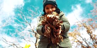 《可爱的小男孩》在秋季向镜头扔落叶——慢镜头