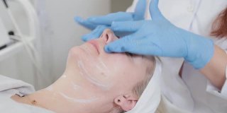 在美容诊所里，专业的美容师给一个女人按摩脸部