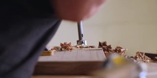 特写镜头。木匠用铣刀在胡桃木板上钻孔。用铣刀进行的木工加工。