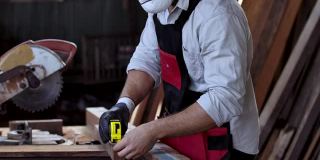 有经验的工匠或木匠穿戴安全个人防护设备，以保护灰尘和事故现场制造使用卷尺测量尺寸和符号。