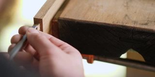 关闭了。木工用木凿把燕尾榫刻进橡木板里。木工工艺,手工艺品。木工工具的声音
