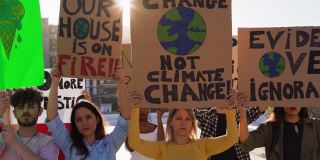 一群年轻的示威者在路上，来自不同文化和种族的年轻人为气候变化——全球变暖和环境的概念而斗争