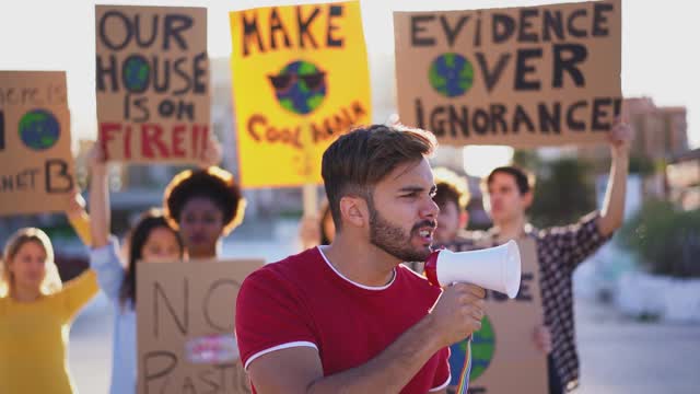 一群年轻的示威者在路上，来自不同文化和种族的年轻人为气候变化——全球变暖和环境的概念而斗争