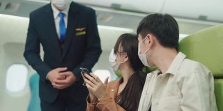 亚洲乘务员用智能手机检查乘客的车票