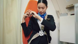穿着制服的美丽亚洲空姐在飞机上系好安全带。视频素材模板下载