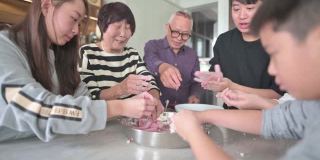 中国的老年人家庭为春节团圆饭准备中国食物“汤圆”糯米团