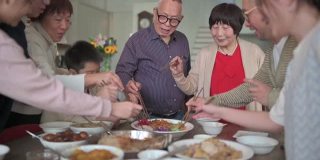 亚洲华人多代家庭庆祝中国新年前夕与传统食物娄桑(生鱼菜肴)团圆饭