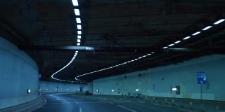 一辆车在夜间行驶在高速公路的隧道里