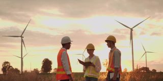 三个工程师在日落时讨论反对风力发电场