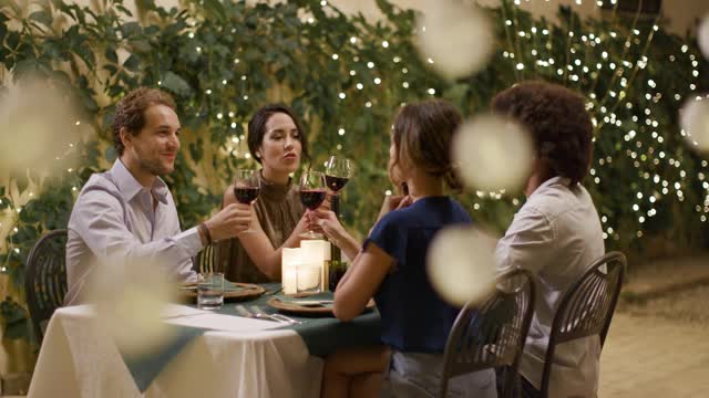 四个人，两对情侣在浪漫的美食晚餐或午餐中畅谈红酒。肖像中景镜头。朋友们在翁布里亚的意大利之旅，4k慢镜头
