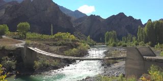 一辆汽车穿过尼泊尔喜马拉雅山脉的危险木吊桥