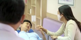 亚洲专业医生与外科医生和病人家属在担架上奔跑和移动昏迷的男性病人通过医院大厅到手术室。医疗保健服务理念。
