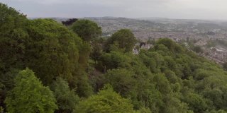 俯瞰英国巴斯市郁郁葱葱的绿色林地的住宅的广阔空中城市景观