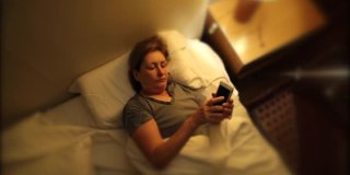 老女人晚上在床上拿手机