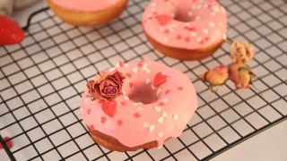 烤架上粉红色的甜甜圈。情人节的概念。女人手里放了一个甜甜圈视频素材模板下载