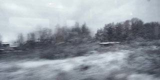 冬天的森林和村庄透过火车的窗户。