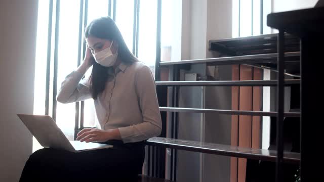 在办公室工作的女性必须一直戴着防护口罩。防止感染的传播。