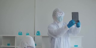 科学家在防护服和防护面罩使用平板电脑视频会议。