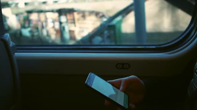 使用移动应用程序。一个男人在火车车厢里使用手机。