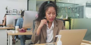 多样化的年轻商务人士在办公室呼叫中心工作。男人和女人用耳机与顾客交谈。电信和呼叫中心服务的职业概念。