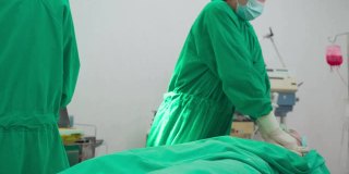 医院手术室的一组医生。亚洲专业的外科医生和护士团队为重症监护患者实施心肺复苏术，并在手术中使用除颤器电击心脏。