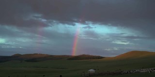 日出时分蒙古草原上的彩虹、蒙古包帐篷和羊群