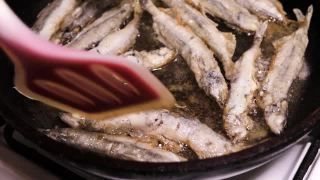 毛鳞鱼是用植物油在平底锅里炸的。烹饪,海鲜。视频素材模板下载