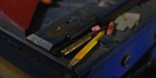 金属工作台工程工具跟踪拍摄。防护手套，卷尺，铅笔，金属剪刀和金属片。在生产锡制品的车间工作