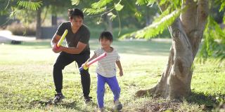 父亲和儿子在公园里打剑，户外。