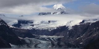 约翰·霍普金斯冰川和它周围的雪山和云。阿拉斯加的冰川湾景观。