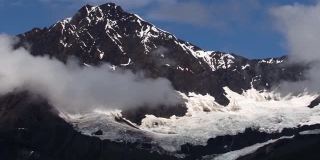 阿拉斯加冰川湾的雪山和冰川周围的小低云。