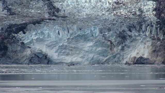 一艘小船载着游客靠近阿拉斯加的约翰霍普金斯冰川。