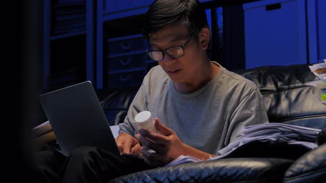 57岁的亚洲老年人在工作到深夜的社交距离中使用笔记本电脑和视频会议技术通过视频会议与医疗工作者交谈。高级健康技术理念。