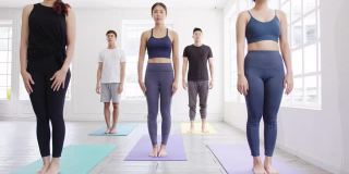 年轻的亚洲体育有吸引力的人练习瑜伽课与教练。亚洲女性群体在健身室锻炼健康的生活方式。