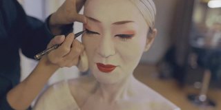 一名日本女性为艺伎化妆