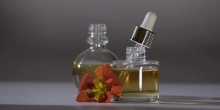 香水。精油产品。从化妆吸液器滴到装有香水的玻璃瓶。皮肤和身体护理。芳香草药和鲜花液体。美容和制药的概念
