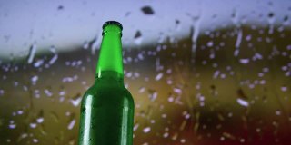 啤酒瓶与效果，特写，轻啤酒在一个瓶子上的背景雨点。啤酒的屏幕保护程序。