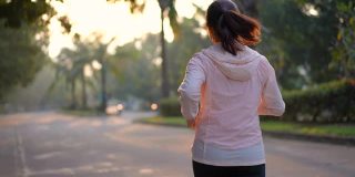 妇女早上在村公园跑步，锻炼和健康的概念