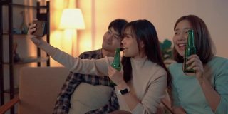 年轻的亚洲朋友在私人聚会上用智能手机自拍。