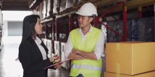 亚洲女经理与男领班在工厂仓库讨论库存计划