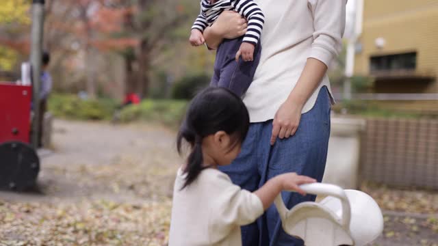 小女孩在公园里玩跷跷板