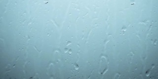 雨的背景，雨滴顺着玻璃流下，美丽的雨滴倾盆而下，窗外是雷雨。