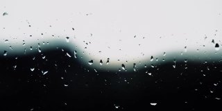 小雨的背景，雨点落在玻璃上，雨点滴在窗户上，窗外闪电，雷雨，雨水倾泻。