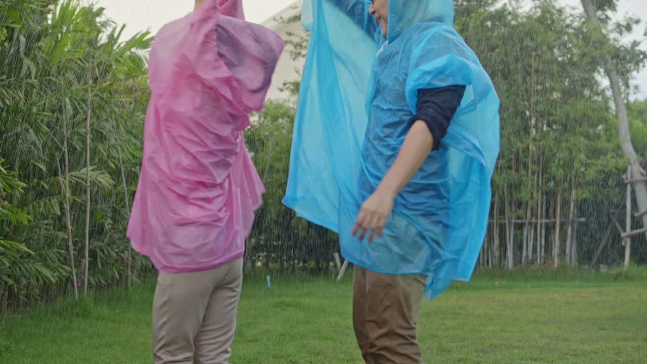 慢镜头中，一对相爱的年轻情侣在雨中嬉戏拥抱