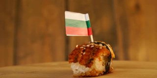寿司配上鱼、米饭、海藻和保加利亚小旗放在上面，在木制的转盘上旋转。