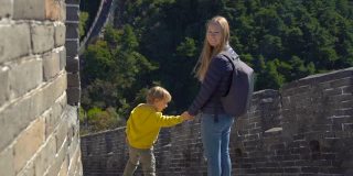 一个快乐的年轻女人和她的小儿子站在中国长城上的慢镜头