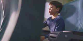 亚洲小男孩玩飞机模型玩具，坐在飞机上。这个孩子感到高兴和兴奋，想成为一名飞行员，作为他的梦想工作，当他长大后驾驶飞机。