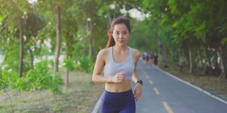 亚洲年轻美丽的女人为健康在傍晚日落在街道上的公园。运动员健康和坚定的女孩锻炼通过慢跑锻炼户外运动为她的健康。